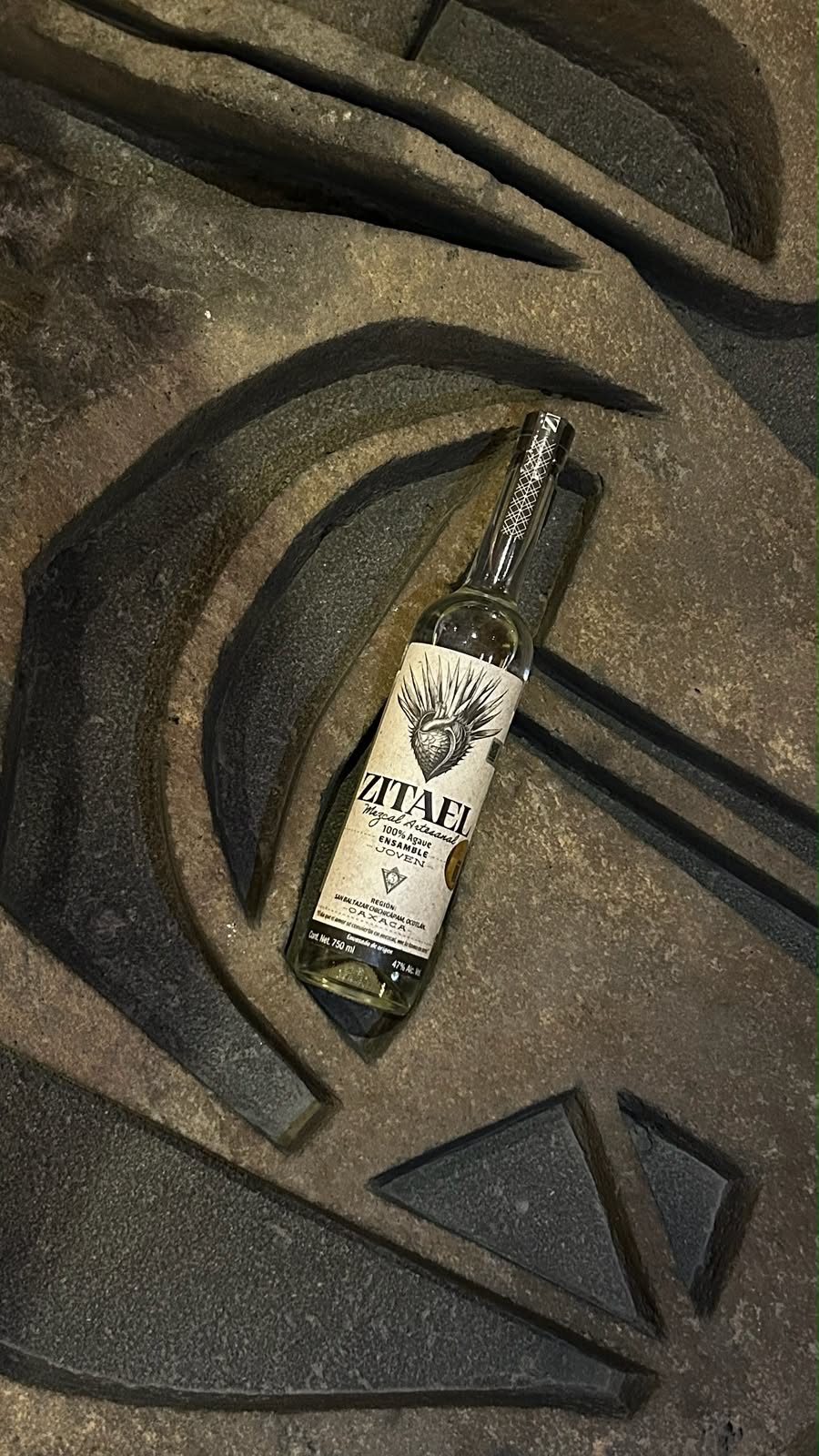 Botella Zitael sobre herrería artesanal con motivo de agave